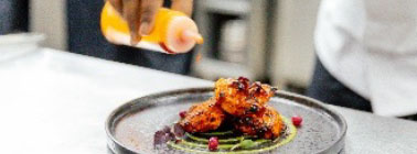 A chef dressing a meal