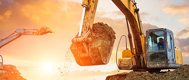 Excavators working at sunrise