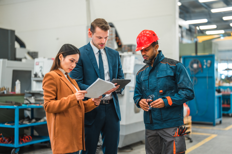 Two people looking over prints with warehouse worker