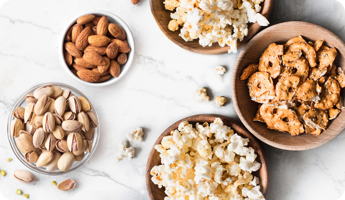 Bowls of popcorn and nuts on a table 