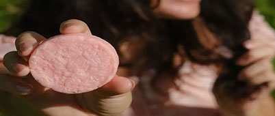 A woman holding up a soap based hair cleanser