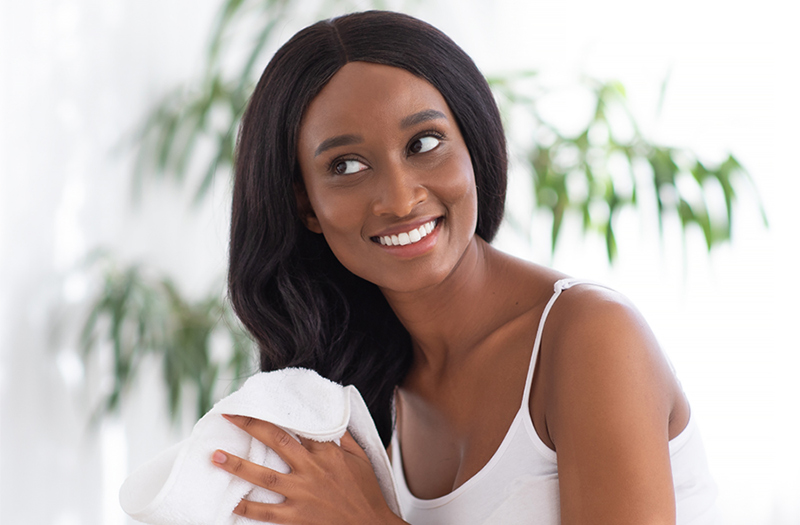 A smiling woman drying her hair