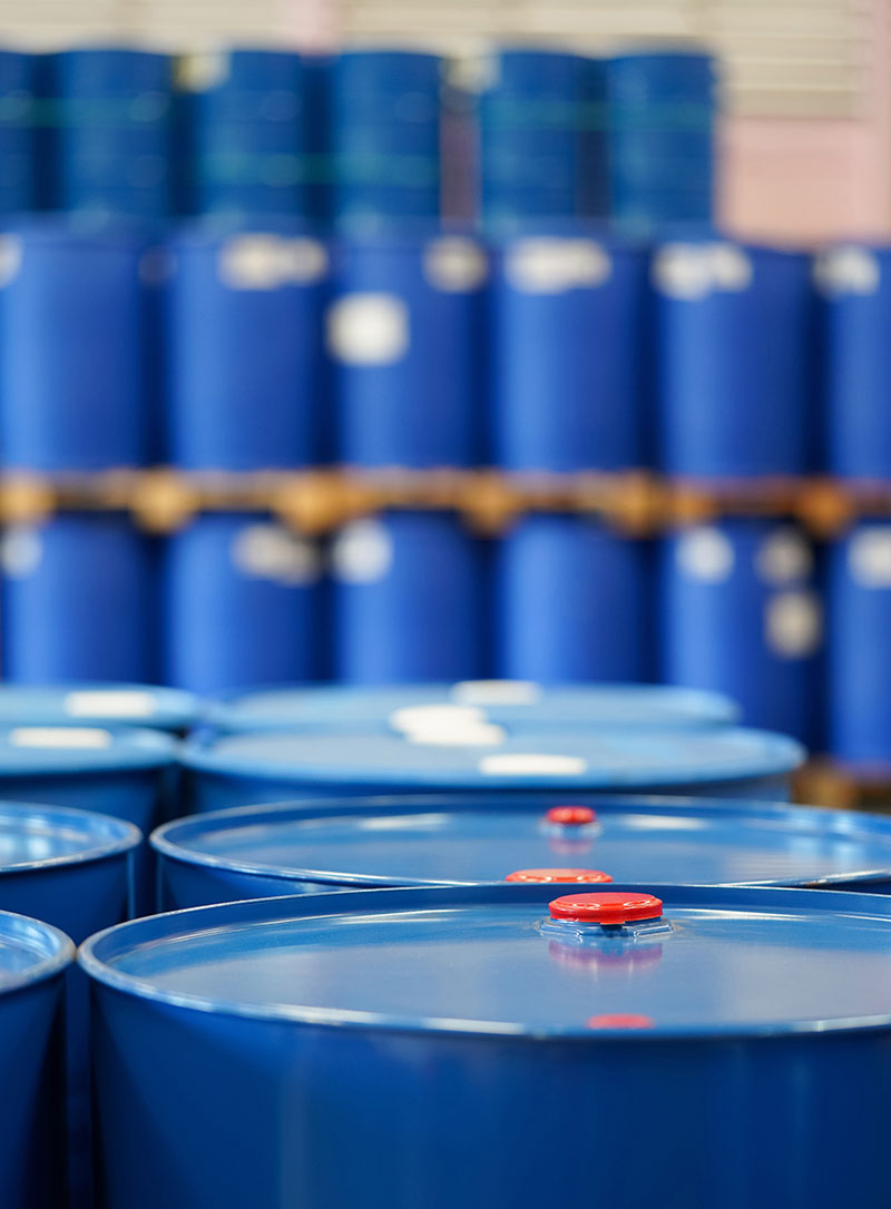 Barrels of chemicals stacked in a warehouse