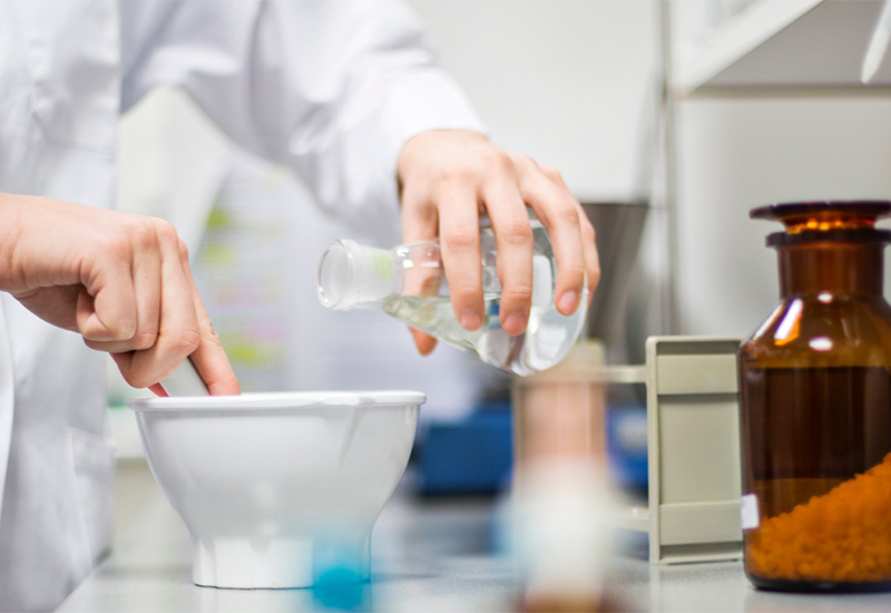 A scientist in a lab mixing chemicals