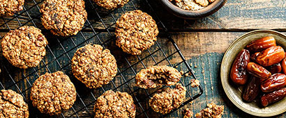 Cookies cooling on a rack with a plate of dates nearby