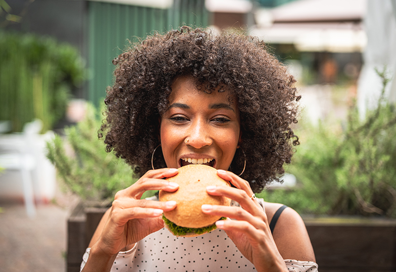 A girl eating a plant-based burger