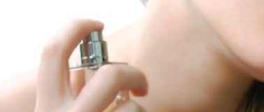 Woman applying perfume