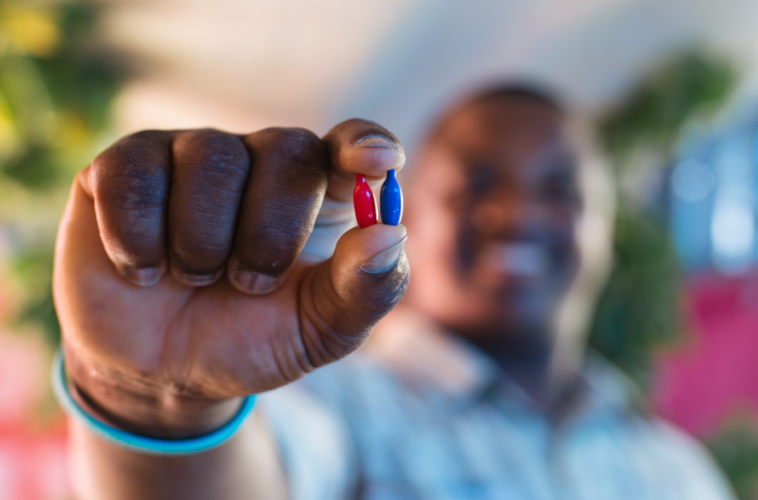 man holds up vitamins