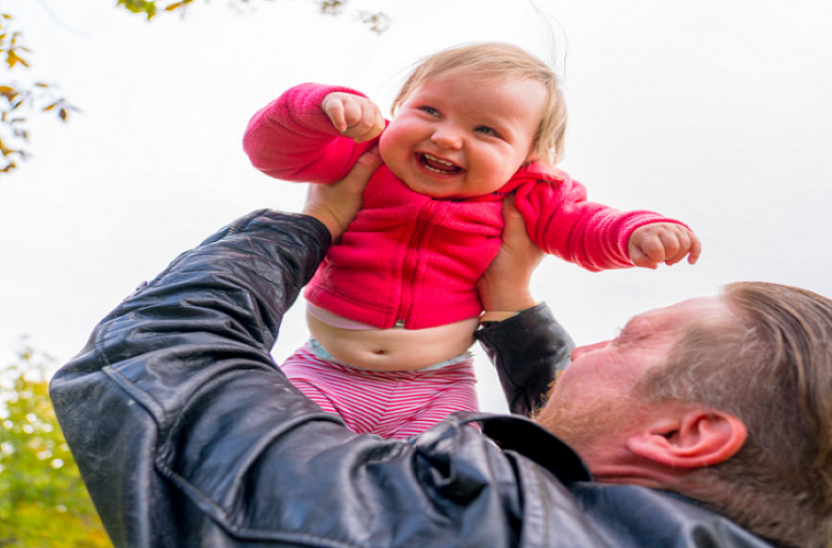 man holds up his child