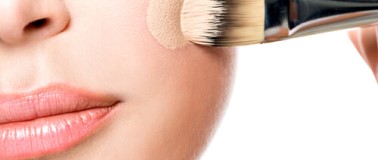 img title Woman applying coverage makeup with an applicator brush