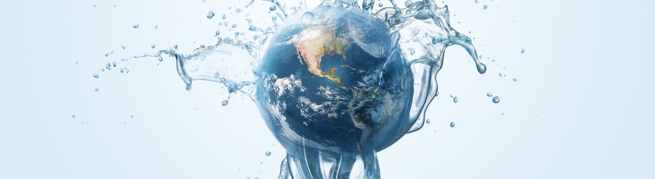 A globe of Earth with a stream of clean water coming up from the bottom and splashing over the Earth.