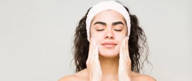 Woman rubbing cleanser into her cheeks