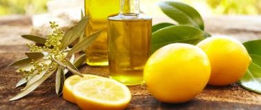Lemon oil in a bottle on a table with lemons
