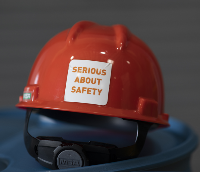 Red hard hat with the words 'serious about safety' written on a sticker