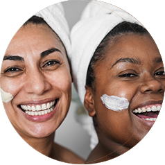 Two women with towels on their hair and cream on their faces