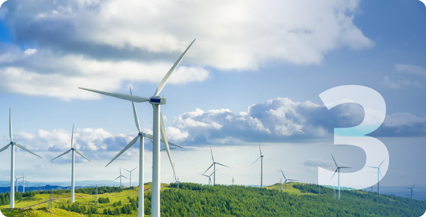A wind farm sits on green rolling hills with a bright blue background
